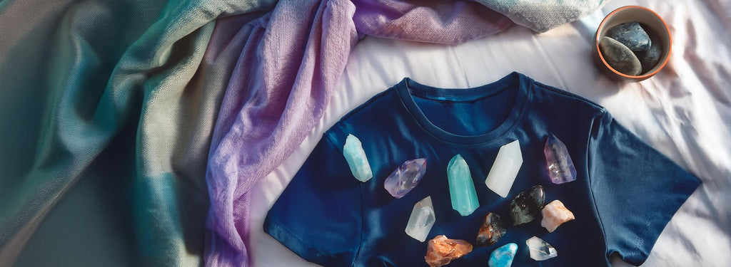 Stack of ethical high vibe clothing with crystals and organic materials